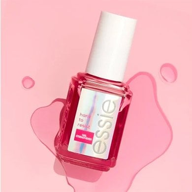 bottle of hard to resist glow & shine by essie against a pink background with water droplets